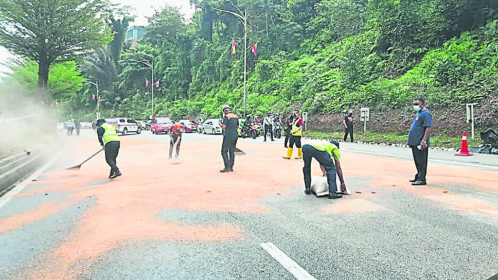 大都会-吉隆坡市政局在有油渍路段撒粉末