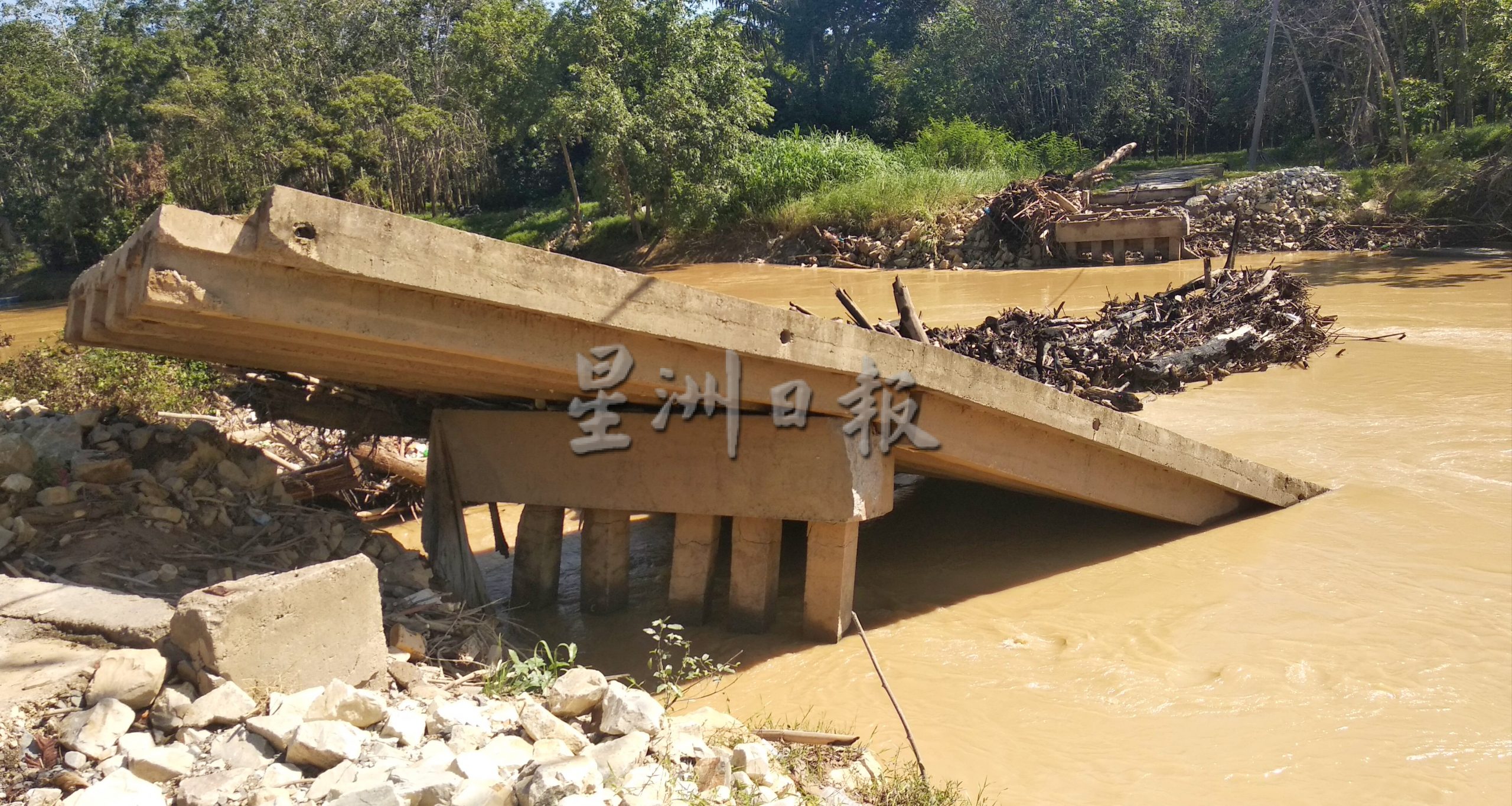 东：文德甲丹绒吉拉央大桥上周被洪水冲垮，昨日终抵挡不住水流断成了两截。