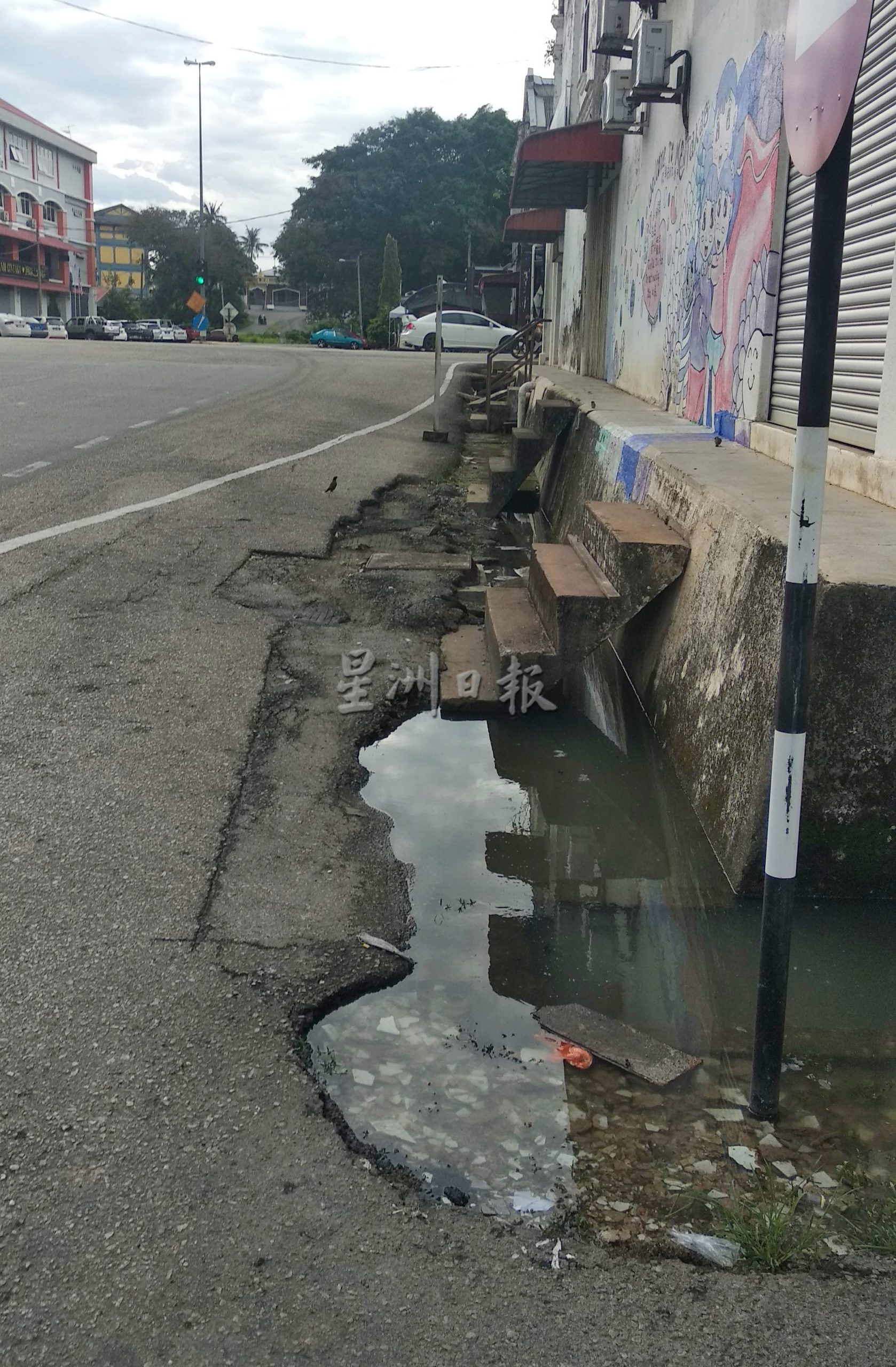 东：文德甲市区淡马鲁路水沟面对严重堵塞，造成沟水大量溢出马路，污水还发出臭味。