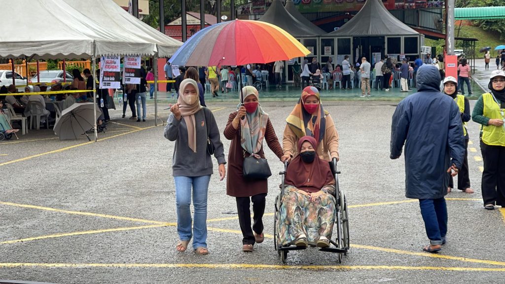 撑伞淋雨 轮椅拐杖·选民风雨无阻投票