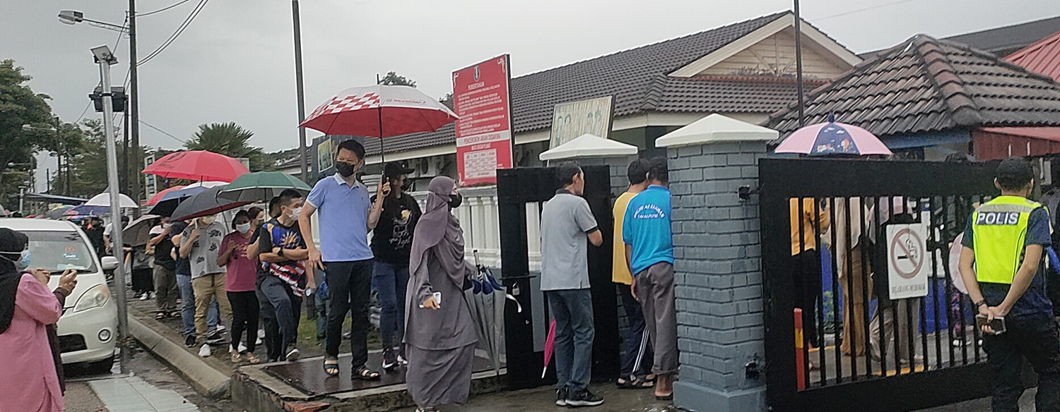 大雨浇不熄欲投票的心，多个投票站可见选民撑伞投票