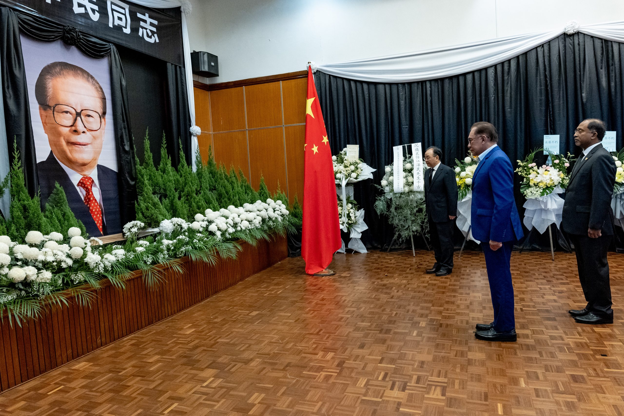 首相安华（中）在外长赞比里（右）陪同下，向已故中国前国家主席江泽民致最后敬意。左为大使欧阳玉靖。（有关当局供图）