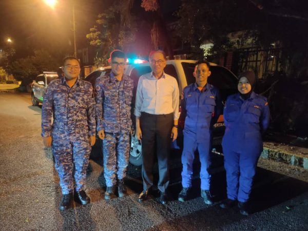 民防人员协助捕获眼镜蛇后跟首相安华合照。 （民防部队脸书）