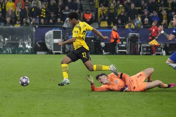 Dortmund's Karim Adeyemi is about to score his side's first goal pass by Chelsea's goalkeeper Kepa Arrizabalaga during the Champions League, round of 16, first leg soccer match between Borussia Dortmund and Chelsea FC in Dortmund, Germany, Wednesday, Feb. 15, 2023. (AP Photo/Martin Meissner)