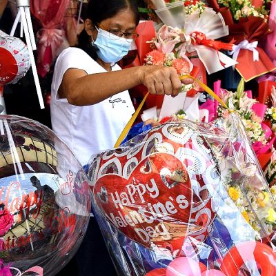 A vendor sells flowers and balloons at a flower market in Manila on Valentine's Day. AFP
