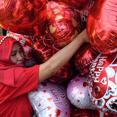 A vendor sells heart-shaped balloons at a flower market in Manila on Valentine's Day. AFP