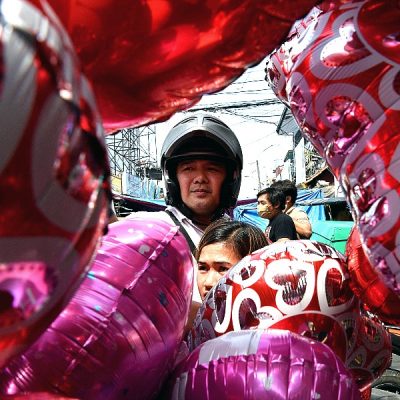 A customer buys heart-shaped balloons at a flower market in Manila on Valentine's Day. AFP
