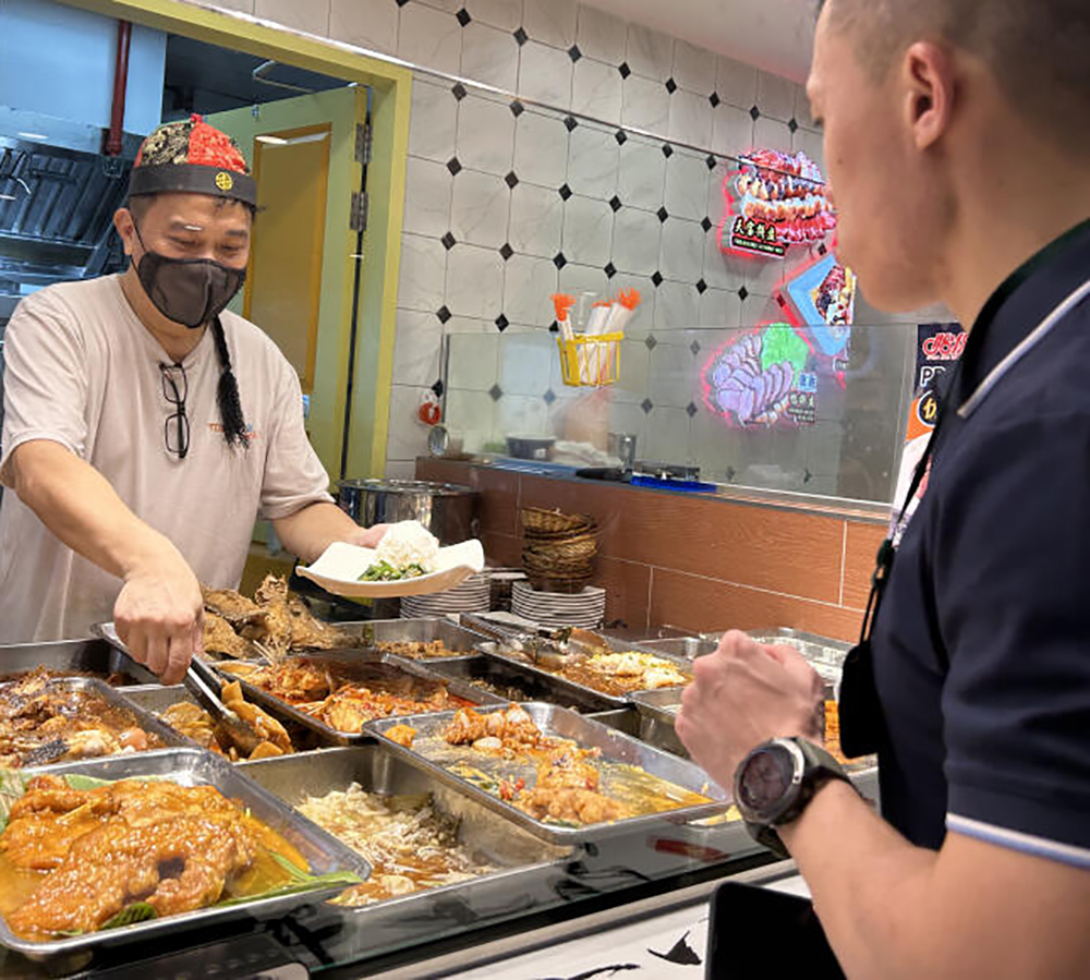 **已签发**柔：狮城二三事：菜饭摊助手变身“财神爷”添饭夹菜，食客赞妙纷拍照