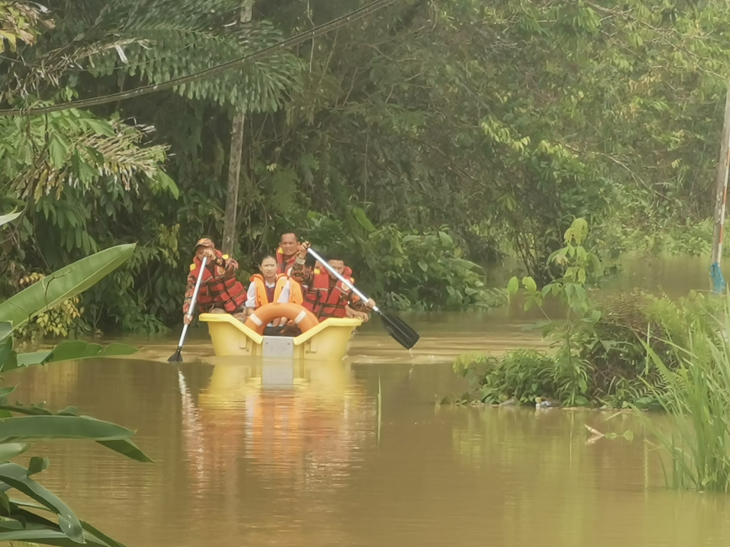 消拯员协助考生越过淹水区前往学校考试