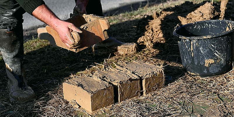 Master builder Janos Gaspar explains the making of bricks of a mud-brick house in Acs. AFP