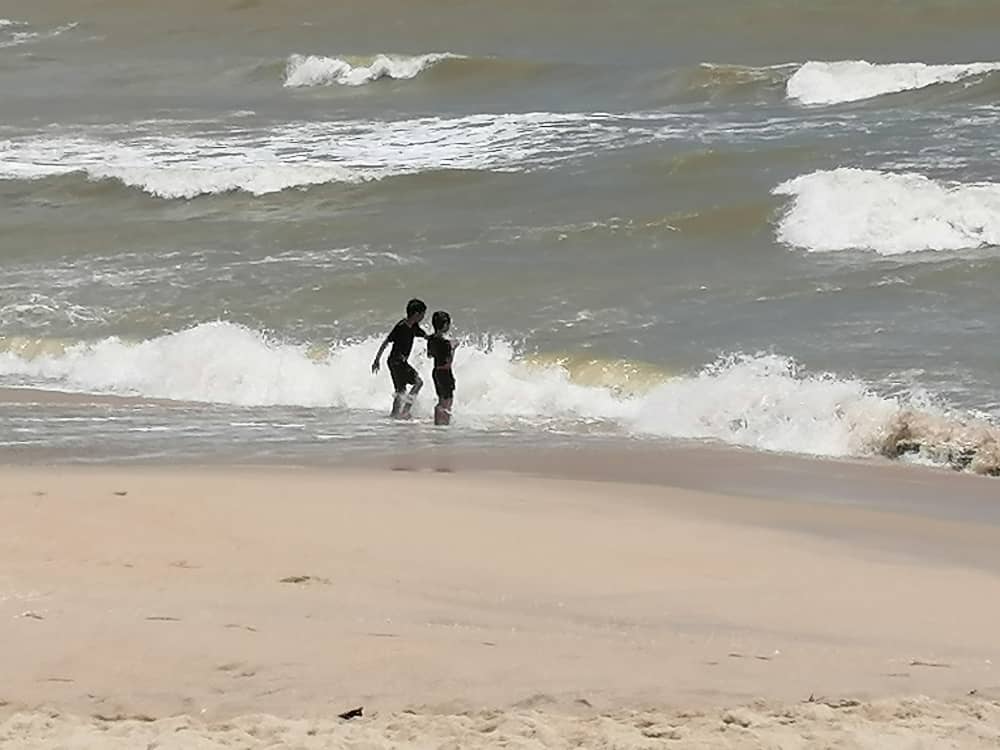 东：直落尖不辣海滩风大浪大并竖起红旗，惟稚儿不懂危险仍在海滩戏水。