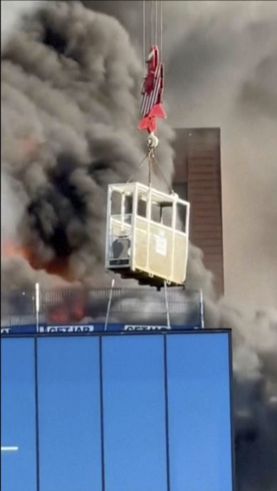 英工人受困失火16楼大厦顶端 吊车垂下吊篮成功救人